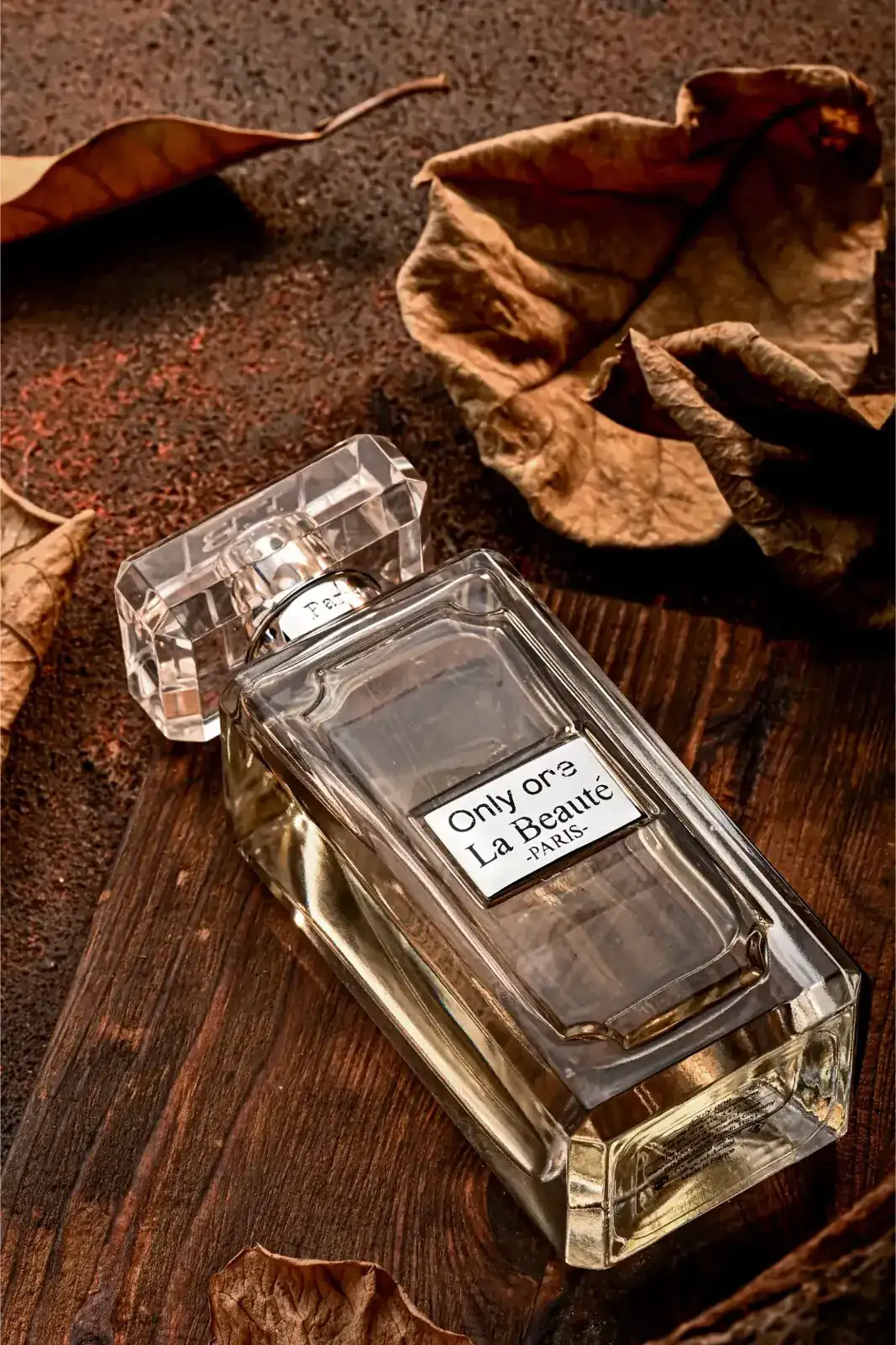 تصوير منتجات — زجاجة عطر بين أوراق الخريف